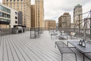 a deck with chairs and tables on a building at 2BR Premium Downtown Suite in Detroit