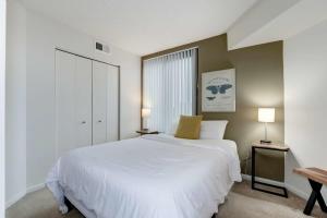 a bedroom with a large white bed and two lamps at 2BR Central Apartment Spacious Layout & Balcony in Arlington
