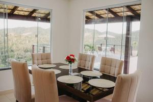 una sala da pranzo con tavolo e sedie di Casa de Campo completa nas montanhas capixabas a Marechal Floriano