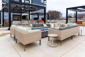 eine Terrasse mit mehreren Sofas und Stühlen auf einer Terrasse in der Unterkunft 2BR Luxury New Apartment with Outdoor Pool in Kansas City