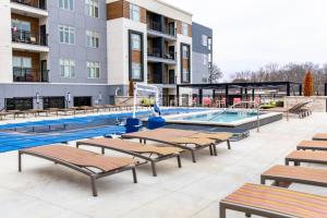 カンザスシティにある2BR Luxury New Apartment with Outdoor Poolの建物の前に長椅子付きのスイミングプール