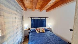 - une chambre dotée d'un lit bleu avec deux oreillers dans l'établissement A Nicaredda, à Cefalù