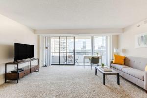 a living room with a couch and a flat screen tv at 2BR Serene Executive Retreat with Balcony in Arlington