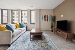 a living room with a couch and a flat screen tv at 2BR Downtown Luxury Getaway in Detroit
