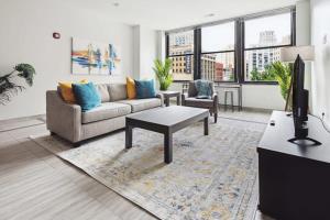 a living room with a couch and a tv at 2BR Executive Downtown Apartment in Detroit