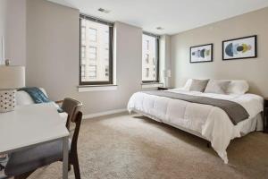 a bedroom with a large white bed and a desk at 2BR Downtown Luxury Getaway in Detroit
