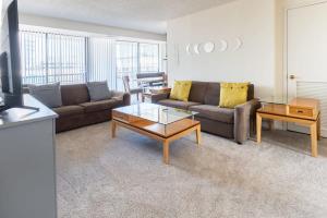 2BR Serene Executive Retreat with Balcony في أرلينغتون: غرفة معيشة مع أريكة وطاولة قهوة
