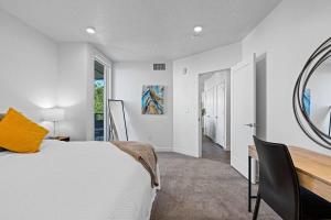 1 dormitorio con cama, escritorio y espejo en 2BR Escape Balcony Gym and Premier Comfort en Salt Lake City