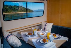 una mesa con dos platos de comida en un barco en Knysna Houseboats, en Knysna