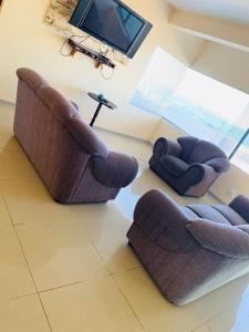 sala de estar con 2 sillas y TV en Kholofelo house, en Saldanha