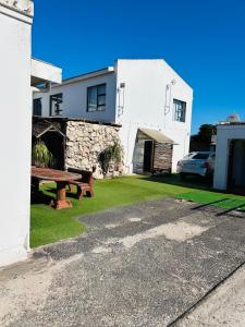 una mesa de picnic frente a una casa blanca en Kholofelo house, en Saldanha