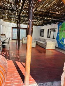 una gran sala de estar con suelo de madera y un poste en Kholofelo house, en Saldanha