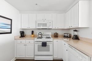 a kitchen with white cabinets and a white stove top oven at 2BR Luxury City Suite With Gym & Pool in Arlington