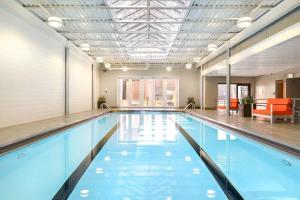 - une grande piscine d'eau bleue dans un bâtiment dans l'établissement 2B 2BA Exquisite Apartment With Views, Indoor Pool & Gym by ENVITAE, à Chicago