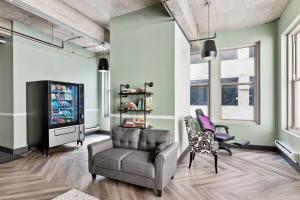 een woonkamer met een fauteuil en een tv bij Spacious & Elegant 2BR Downtown Retreat in Kansas City