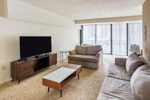 a living room with a couch and a flat screen tv at 2BR Premium A-Location Apartment in Arlington