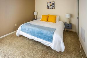 a bedroom with a large bed with blue and yellow pillows at 2BR Premium A-Location Apartment in Arlington