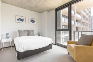 シカゴにある2BR Chic New Apartment With Rooftop Pool & Gymの白いベッドルーム(ベッド1台、ソファ付)