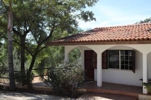 a small white house with a red roof at Casa Luna Viñedo in Valle de Guadalupe