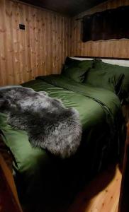 a black dog laying on top of a bed at Cabin Aurora Borealis in Sommarøy