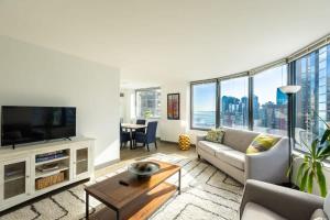 uma sala de estar com um sofá e uma televisão em Ultimate 3BR Luxury Suite near Navy Pier with Gym & Pool by ENVITAE em Chicago