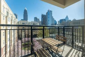 a bench on a balcony with a view of a city at 3BR Premium Downtown Apartment with Office & Gym in Charlotte