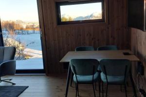 a room with a table and chairs and a window at Cabin Aurora Borealis in Sommarøy