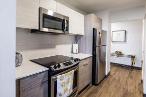 uma cozinha com um fogão e um micro-ondas em Ultimate 3BR Luxury Suite near Navy Pier with Gym & Pool by ENVITAE em Chicago