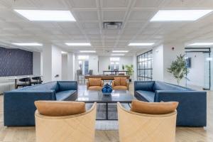 un vestíbulo de oficina con sofás azules y una mesa en 3BR Premium Downtown Apartment with Office & Gym en Charlotte