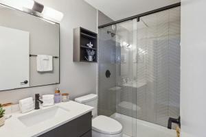 a bathroom with a shower and a toilet and a sink at 2BR Vibrant South Loop Apartment in Chicago