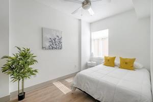 a white bedroom with a bed and a ceiling fan at 4B 3BA Premium Family Apartment with Gym in Charlotte
