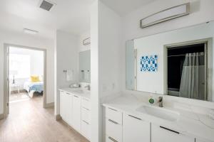 a white bathroom with two sinks and a mirror at 4B 3BA Premium Family Apartment with Gym in Charlotte +28 photos