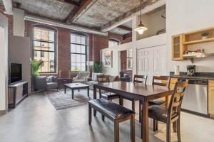 a kitchen and living room with a table and chairs at 2BR 2BA Lux Historic Loft With Pool in Pittsburgh