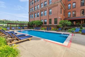 a swimming pool with lounge chairs and a building at 2BR 2BA Lux Historic Loft With Pool in Pittsburgh