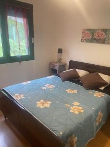 - un lit avec une couette bleue et des fleurs dans l'établissement Maison individuelle a Arreau, à Arreau