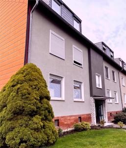 um edifício cinzento com janelas brancas e um arbusto em Schöne 3-Zimmer-Wohnung nahe Düsseldorf Flughafen und Messe em Duisburg