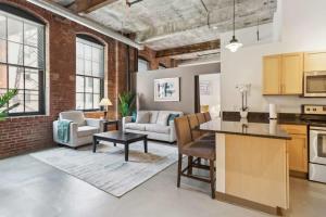 een open keuken en een woonkamer met een bakstenen muur bij 2BR 2BA Historic Loft Retreat With Pool in Pittsburgh