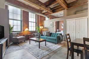 uma sala de estar com um sofá e uma mesa em 2BR Spacious Historic Loft With Pool em Pittsburgh