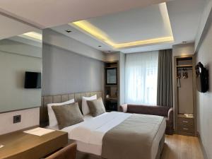 a bedroom with a large white bed and a desk at AHC Grand Bazaar Hotel in Istanbul