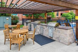 d'une terrasse avec un grill, une table et des chaises. dans l'établissement 2BR Spacious Historic Loft With Pool, à Pittsburgh