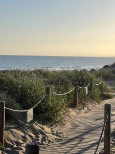 een pad naar het strand met de oceaan op de achtergrond bij STYLISH TOWNHOUSE IN BEACHFRONT COMPLEX in Marbella +20 foto's