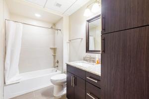a bathroom with a toilet and a tub and a sink at 2BR Distinguished Apartment Rooftop Deck & Gym in Baltimore +26 photos