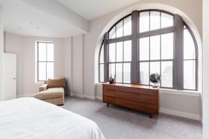 a bedroom with a bed and a large window at 2B 2BA Luxury Downtown Suite Rooftop Deck & Gym in Baltimore