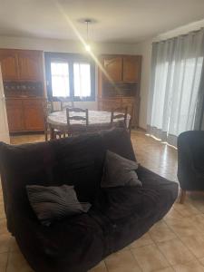 - un salon avec un canapé noir et une table dans l'établissement Maison individuelle a Arreau, à Arreau