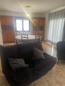 a living room with a black couch and a table at Maison individuelle a Arreau in Arreau +14 photos