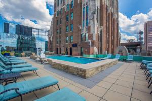 a pool on the roof of a building with chairs at 2B 2BA Luxury Downtown Suite Rooftop Deck & Gym in Baltimore
