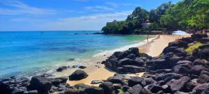 a beach with rocks and people on the water at Furnished Townhouse - Grand Baie in Grand Baie
