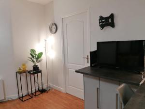 a living room with a flat screen tv and a door at Modern Home proche de Disneyland et Paris in Champs-Sur-Marne