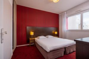 The Originals Residence KOSY appart'hôtels - Les Cèdres tesisinde bir odada yatak veya yataklar
