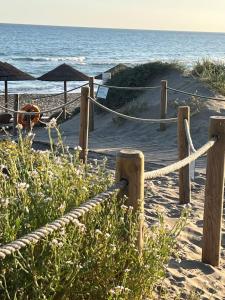 een touwhek op een strand met de oceaan bij STYLISH TOWNHOUSE IN BEACHFRONT COMPLEX in Marbella